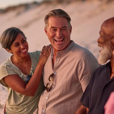 Mature couple on the beach laughing